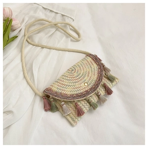 Detail of bohemian straw bag with colorful fringe tassels and wave stitching
