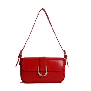 Retro wine red patent leather shoulder bag with chic golden horseshoe buckle on white background