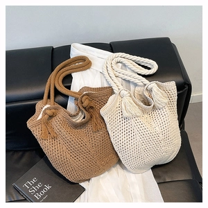 Detail view of woven knit bucket bags with thick rope handles and fringe tassels