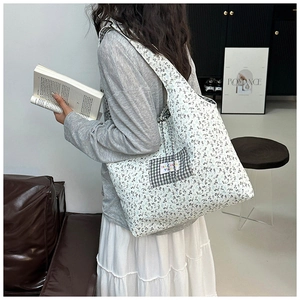 Détail du sac cabas floral avec écusson à carreaux noir et blanc et étiquette de logo