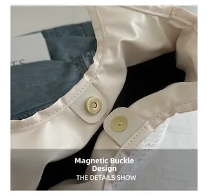 Detail view of the magnetic snap closure on the beige faux leather lace tote bag