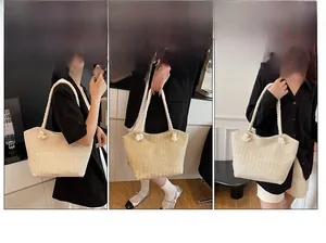 Detail of cream woven tote bag featuring thick knotted rope handles and textured finish