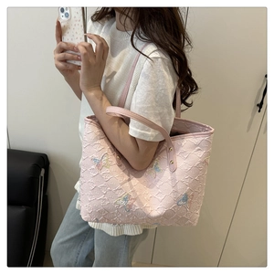 Dettaglio della borsa tote rosa trapuntata con ricamo di farfalla in paillettes