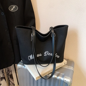 Large capacity black canvas tote bag with script print on silver suitcase setting