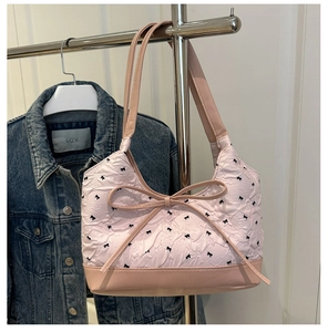 Detail view of pink ruffled texture bag with black bow embroidery and ribbon accent