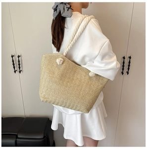Detail of hand-woven straw tote bag with cotton rope handles and herringbone pattern