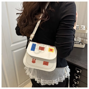 Gros plan du sac à bandoulière blanc avec autocollants colorés et sangle réglable