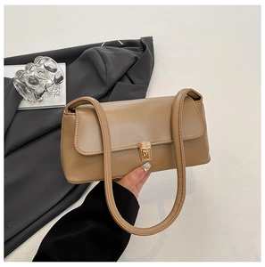Detailed view of khaki baguette bag featuring gold metal clasp and smooth faux leather finish
