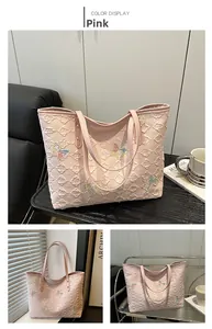 Dettaglio della borsa rosa con trama a rombi a rilievo e ricami di farfalle colorate