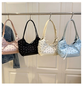 Detail shot of four bow-accented shoulder bags in pink, black, white, and blue colors