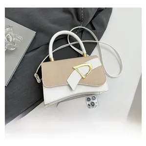 Detail of elegant two-tone crossbody bag with gold D-buckle and woven leather texture