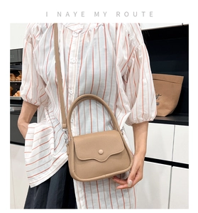 Detail of apricot saddle bag with lychee pattern leather and adjustable shoulder strap