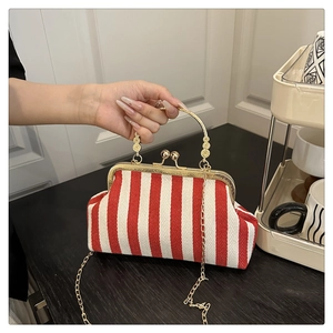 Detail of red and white striped vintage clasp handbag with gold circular metal handle