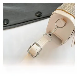 Detailed close-up of the adjustable strap and sparkling sequin texture on a cream shoulder bag