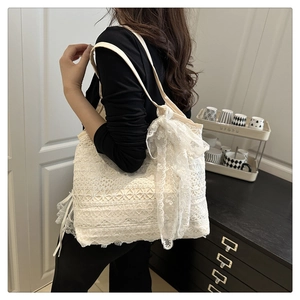Detailed view of the layered white lace tote bag featuring a large decorative side bow