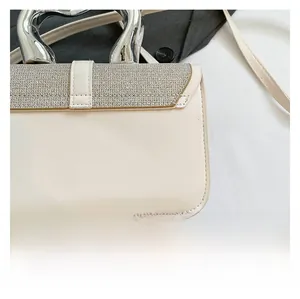Detail of beige faux leather crossbody bag with glitter flap and silver metal handle