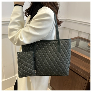 Detail of dark green quilted tote bag with matching coin purse shown on model