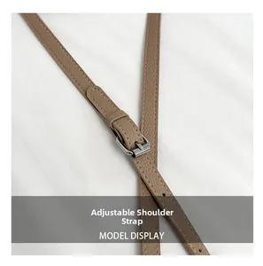 Detail of adjustable litchi texture leather strap with silver metal buckle in brown