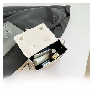Internal view of a white leather crossbody bag showing space for phone and cosmetics
