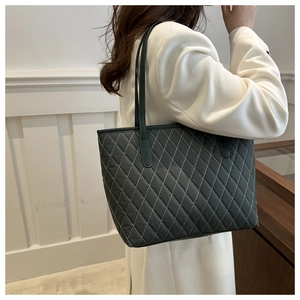 Detail of dark green quilted tote bag featuring elegant diamond stitching on nylon fabric