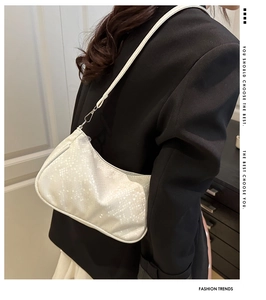 Détail du sac sous le bras en faux serpent blanc avec boucles en métal argenté