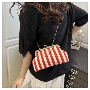 Detail view of red and white striped crossbody bag with vintage gold clasp and chain strap