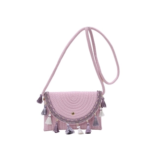 Bohemian pink woven saddle bag with colorful tassels and wave trim for summer beach vacation