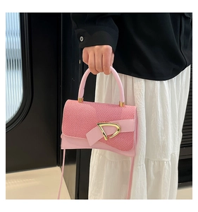 Detail of pink leather handbag showing woven flap texture and gold D logo buckle