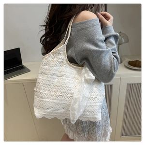 Vue latérale détaillée du sac cabas en dentelle florale blanche avec un grand nœud sur modèle