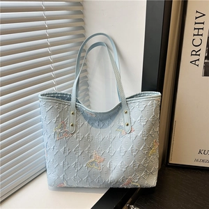 Borsa tote trapuntata azzurra con ricami di farfalle colorate e motivo a logo
