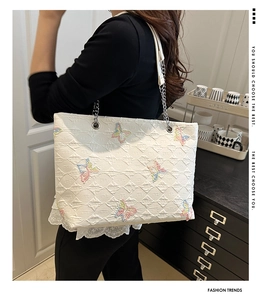 Close-up of colorful butterfly embroidery and diamond quilting on the white tote bag