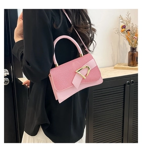 Detailed view of pink handbag with striped texture flap and gold D-ring buckle
