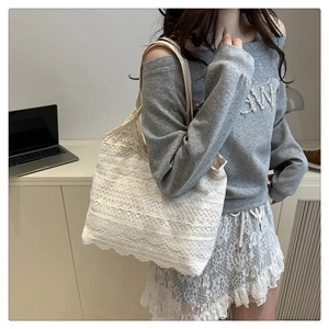 Close-up of white floral lace tote bag with delicate embroidery and fabric straps