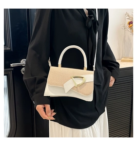 Close-up of beige woven texture and white leather handbag with golden D buckle