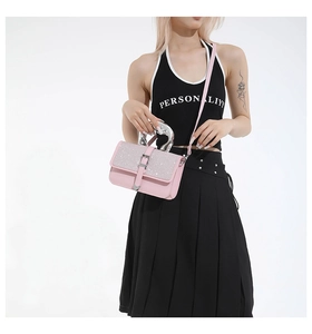Pink sequin crossbody bag with silver metallic handle shown on a stylish model