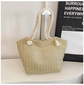 Detail of straw woven tote bag showing herringbone pattern and cotton rope handle