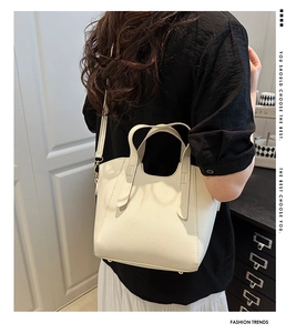 Dettaglio della borsa tote in pelle martellata crema con manico e piedini d'oro