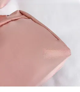 Gros plan sur la texture du tissu en nylon rose d'un sac minimaliste montrant le tissage