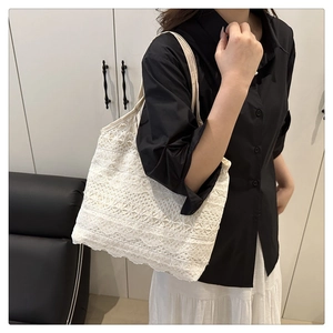 Vue latérale d'un sac cabas en dentelle blanche à motif floral sur un mannequin