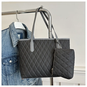 Detail of dark grey quilted tote bag with matching zippered pouch on a hanger
