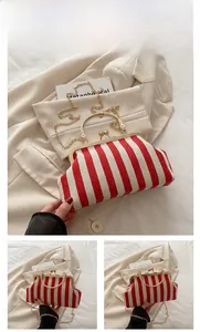 Detailed view of red and white striped fabric texture with vintage gold clasp and chain