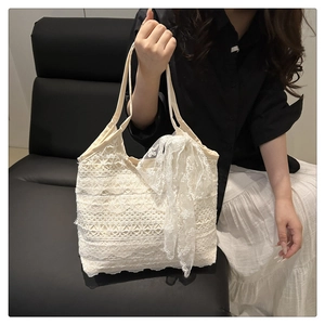 Détail du sac cabas en dentelle blanche à plusieurs niveaux avec nœud décoratif