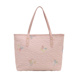 Borsa tote rosa con ricami a farfalla e texture trapuntata su sfondo bianco