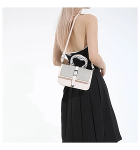 Detail of silver sequin flap and sculptural metallic handle on a beige leather handbag