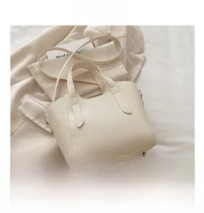 Dettaglio della borsa in pelle martellata bianco crema con borchie metalliche sul fondo