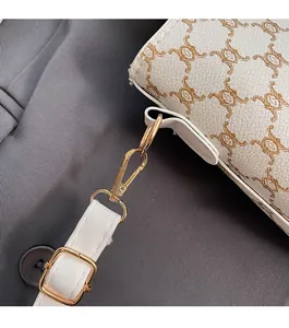 Détails de la boucle dorée et du motif vintage sur le sac seau couleur crème