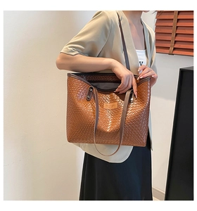 Detailed view of the brown woven geometric texture on this elegant leather tote bag
