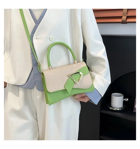 Detail of green leather and woven fabric handbag with a golden D-ring buckle
