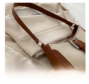 Macro detail of canvas and leather patchwork bag with a vintage silver metal buckle