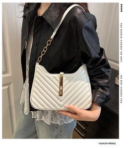 Detail of white quilted faux leather handbag with gold chain strap and metal lock